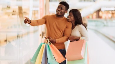 portrait of black couple with shopping bags pointing at window जनता को मिली महंगाई से बड़ी राहत, एमआरपी रेट में हुई बड़ी गिरावट…